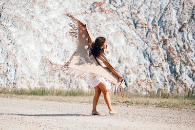 Rear view of woman jumping on field