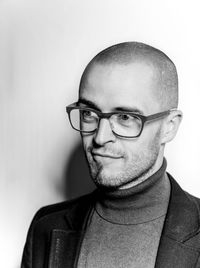 Portrait of young man wearing eyeglasses against white background