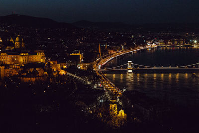 High angle view of illuminated bridge over river in city at night