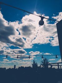 Low angle view of power line against cloudy sky