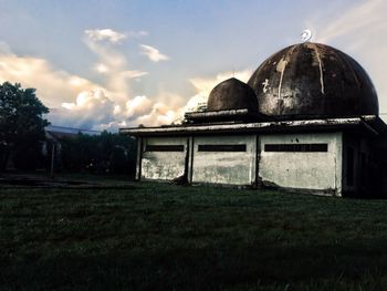 Abandoned building on field against sky