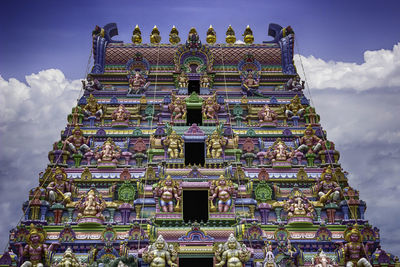 Low angle view of historic colorful temple against cloudy sky