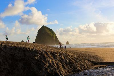 People at beach against sky