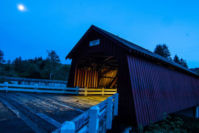 Illuminated covered walkway in forest at night