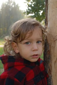 Close-up portrait of cute girl against tree