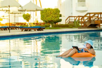 Woman sitting in swimming pool