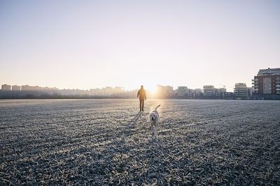 Man with dog on land against sky