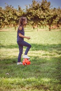 Side view of girl playing on field