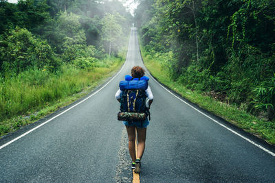 Rear view of woman walking on road