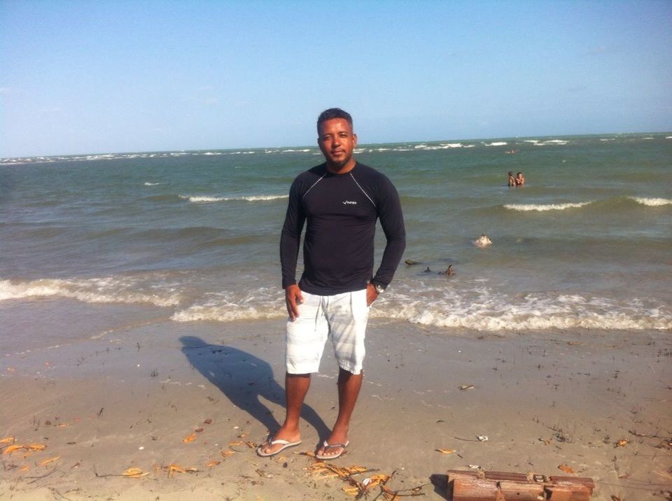 FULL LENGTH PORTRAIT OF A MAN WITH SURFBOARD