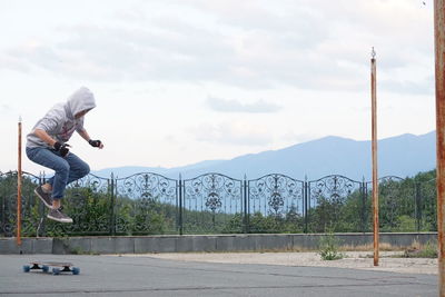 Full length of boy skateboarding outdoors