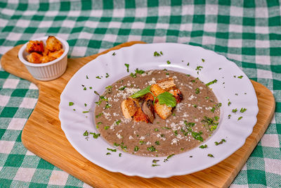 Mushroom soup crutons basilico green white plate