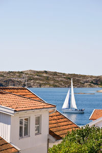 Houses by sea against clear sky