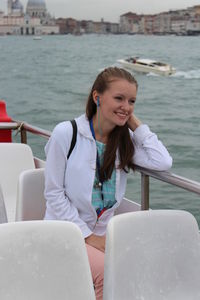 Portrait of a smiling young woman sitting in boat