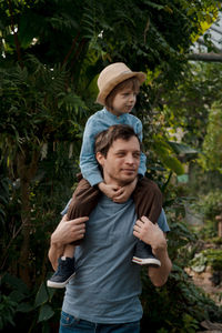 Dad and son inspecting tropical gallery in botanical garden. local travel and tourism.