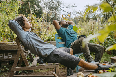 Male farmers resting on wooden chair in urban garden