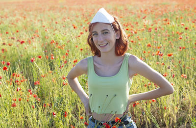 Portrait of young woman standing on field