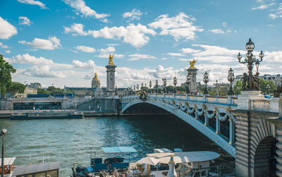 View of bridge over city against cloudy sky