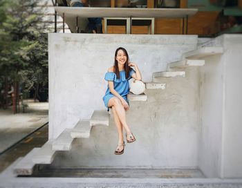 Full length of woman sitting on staircase