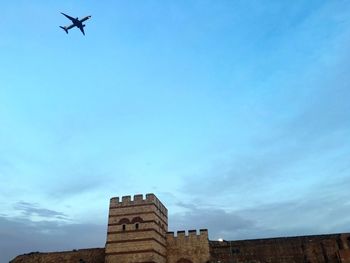 Low angle view of airplane against blue sky