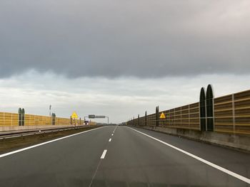 View of highway against cloudy sky