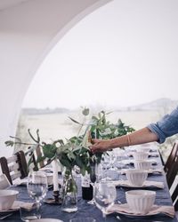 Cropped hand of man table setting outdoors