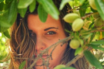 Close-up portrait of woman amidst branches