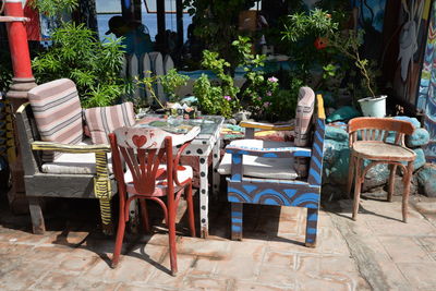 Empty chairs and tables at sidewalk cafe