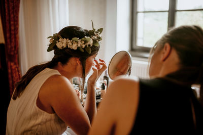 Young woman applying makeup.