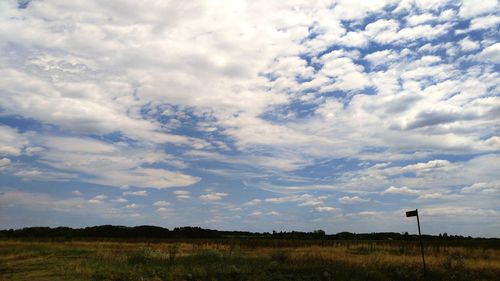 Scenic view of field against cloudy sky