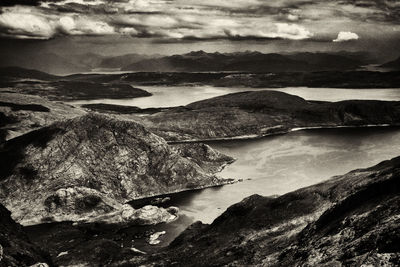 Scenic view of river by mountains against sky