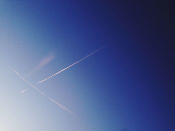 Low angle view of vapor trail against clear blue sky