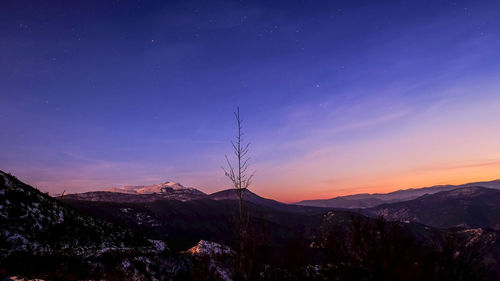 Scenic view of silhouette mountains against sky at night