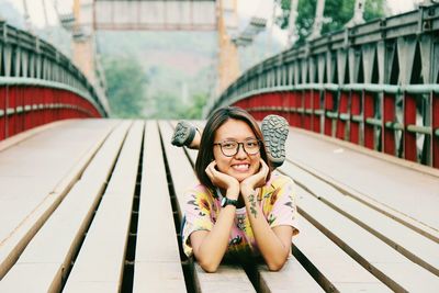 Portrait of woman lying on footbridge