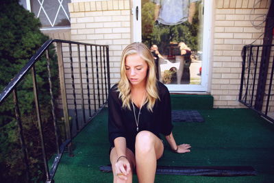 Portrait of a young woman standing on tiled floor