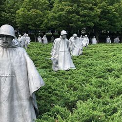 Statues on field against trees