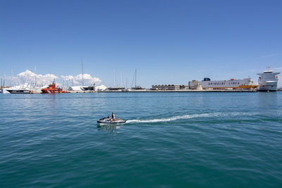 Sailboats in sea against clear blue sky