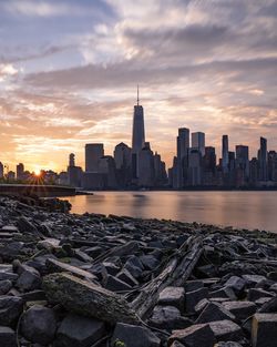 One world trade center in city against sky during sunset