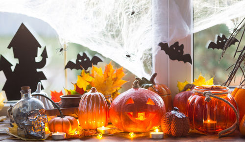 Close-up of illuminated pumpkins against orange wall