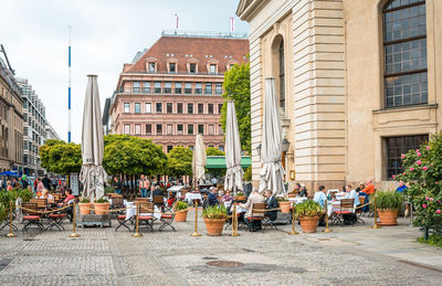 People at cafe by buildings