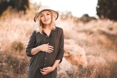 Pregnant woman standing in field