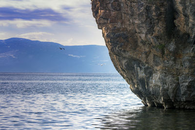 Rock formation in sea against sky