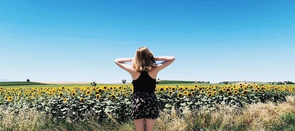 Woman standing on field against clear sky