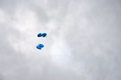 Low angle view of balloons flying against sky