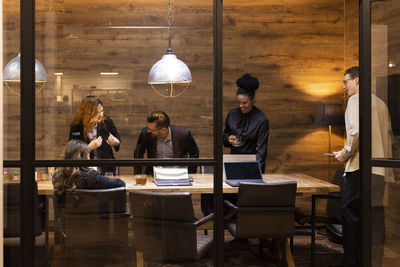 Smiling colleagues in board room at office during meeting