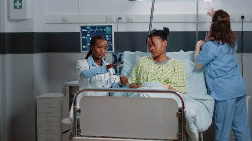 Portrait of female friends using laptop at clinic