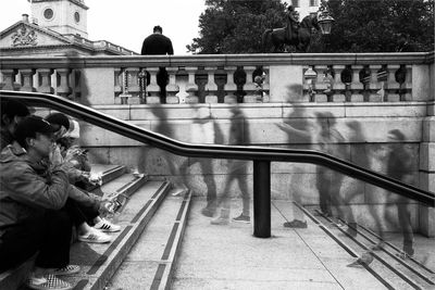 People standing on railing of railroad tracks