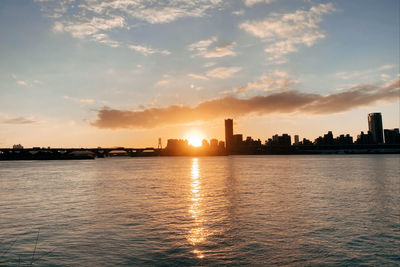 Scenic view of sea and buildings against sky during sunset
