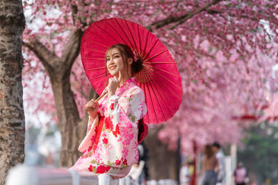 Low angle view of woman holding umbrella