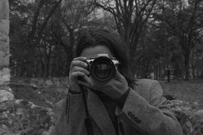 Portrait of man photographing camera on tree